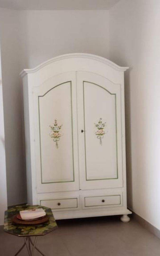 Elegante armadio bianco con decorazioni floreali, 2 porte e 2 cassetti in una camera.