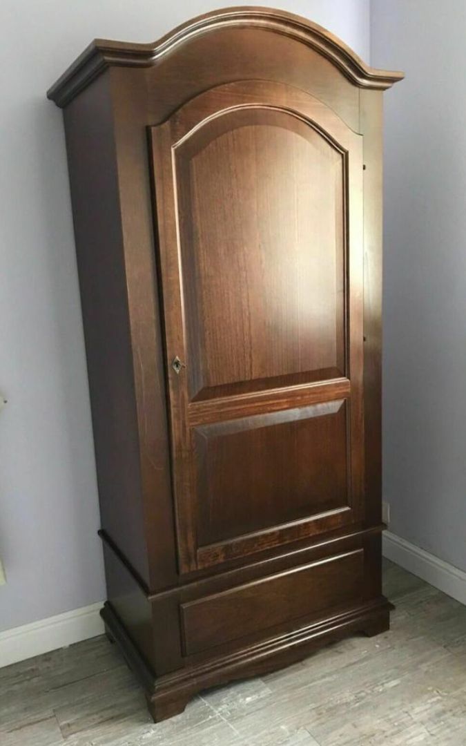 Armadio a un'anta in legno noce scuro aperto, che mostra lo spazio interno.