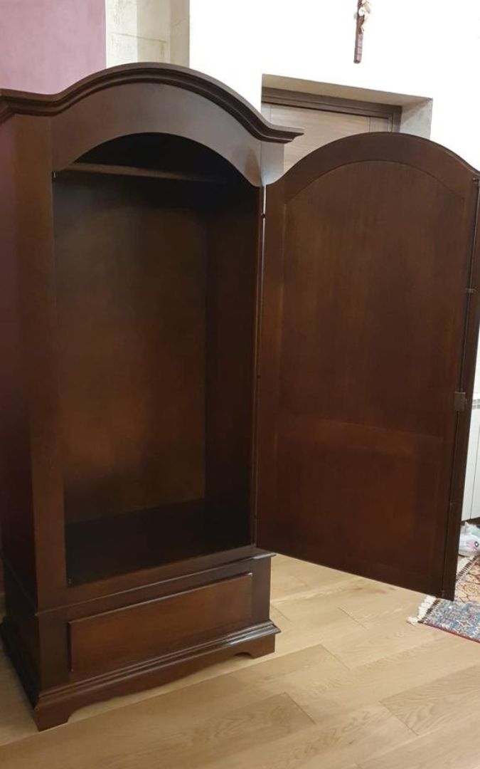 Armadio a una porta in legno noce scuro con cassetto, situato in un soggiorno vicino a un acquario.