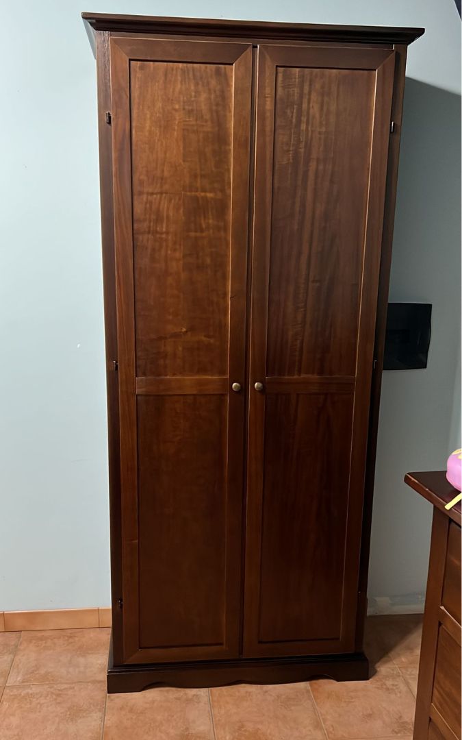 Armadio stipo in legno noce scuro con anta aperta che mostra il vano porta scope e i ripiani interni.