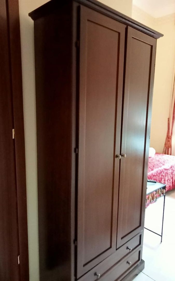 Armadio in legno noce scuro a due ante con due cassetti, design tradizionale aperto.