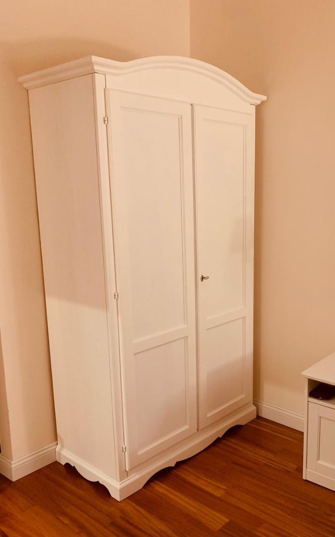 Armadio classico due ante colore bianco posizionato in camera da letto