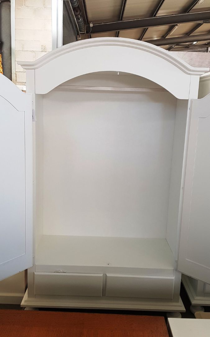 Vano interno di armadio classico bianco, asta appendiabiti e cassetti, inquadratura ravvicinata.