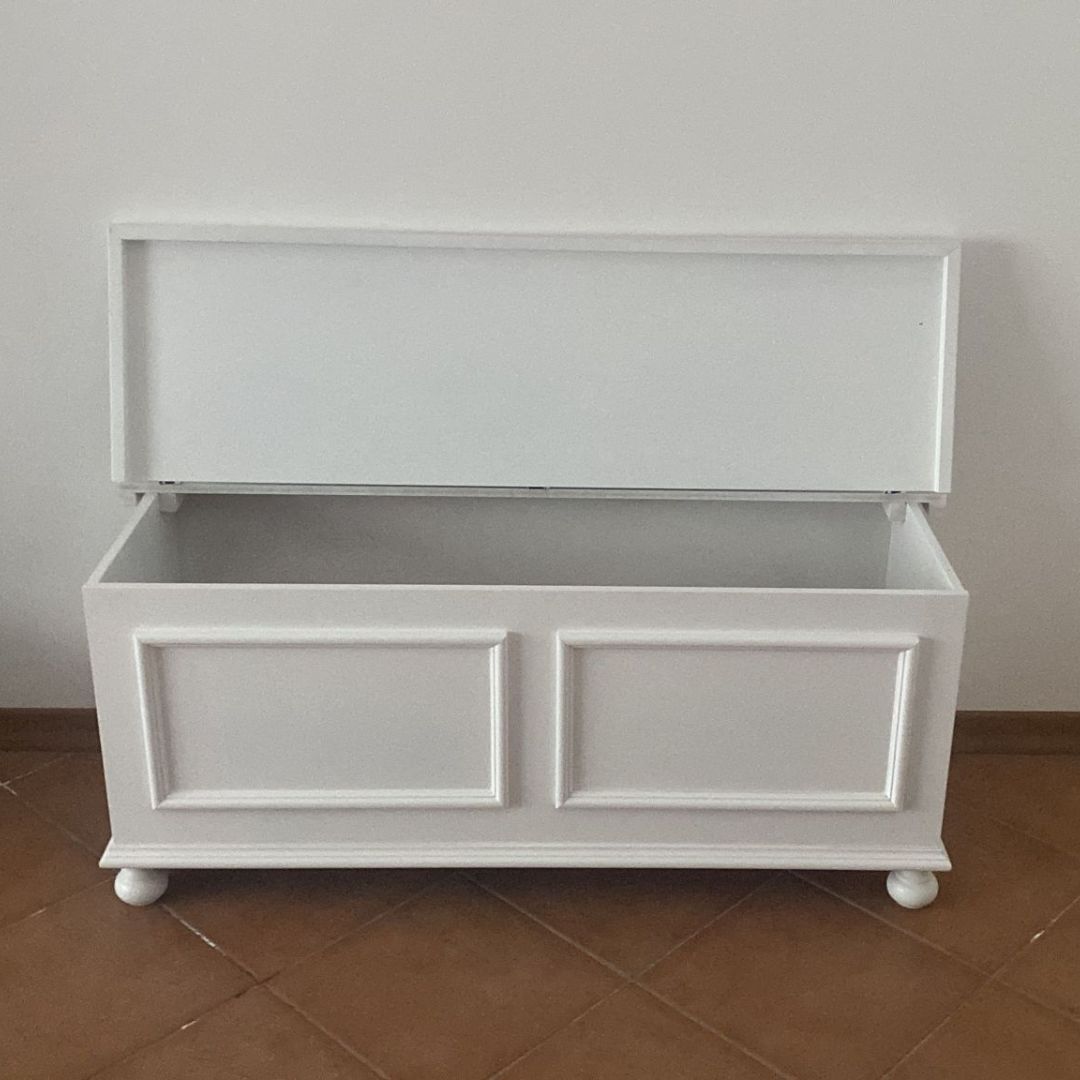 Cassapanca in legno bianco stile classico, aperta, con vista nitida sul vano interno spazioso.