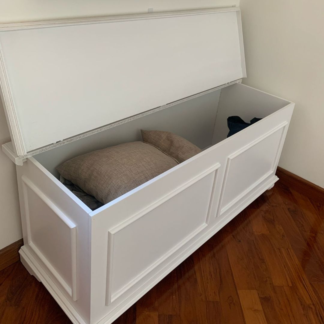 Cassapanca bianca classica aperta con cuscini all'interno, ideale per arredamento camera o soggiorno.