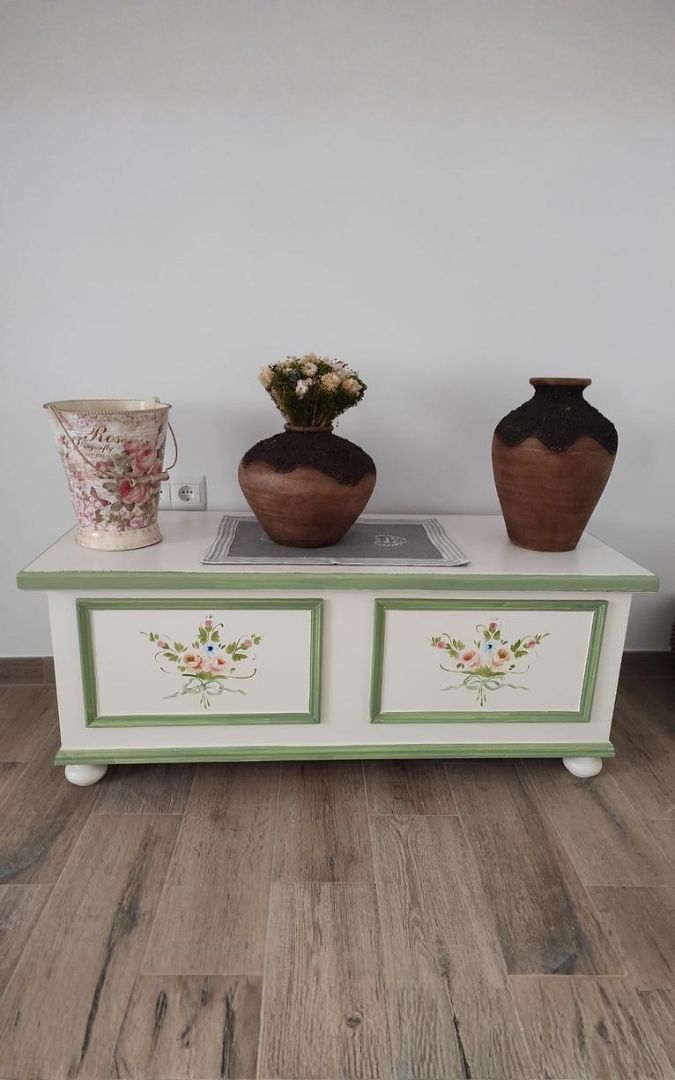 Cassapanca bianca decorata con vasi di fiori sopra