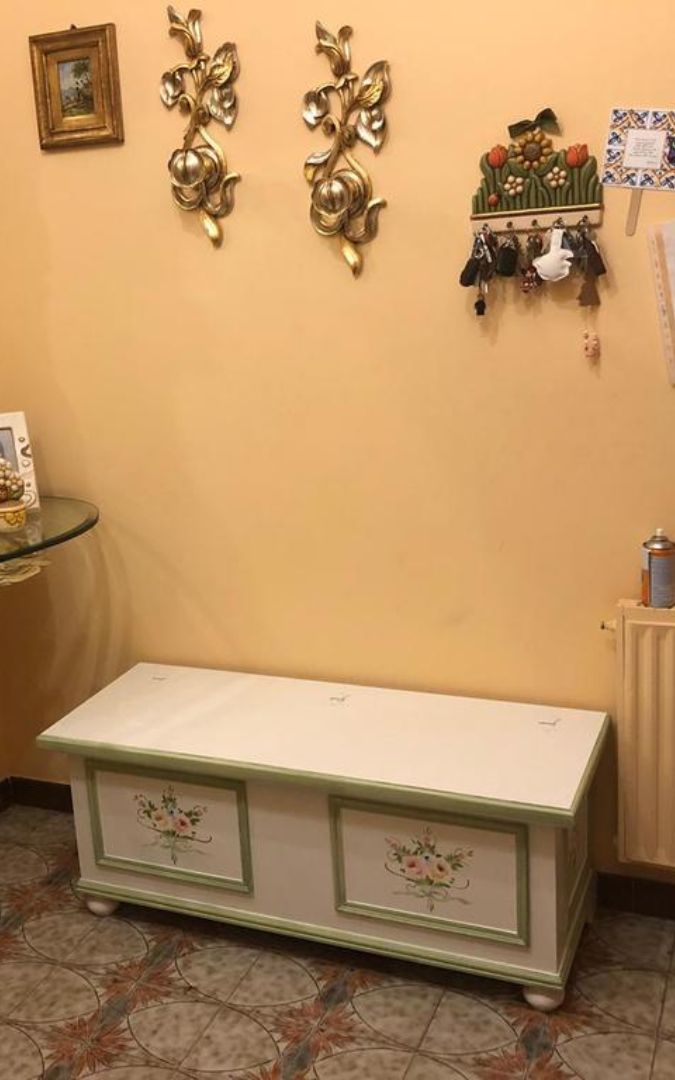 Cassapanca decorata in stile classico posizionata in un ingresso