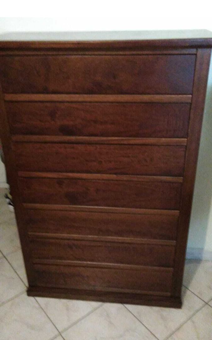 Cassettiera in stile Arte Povera in legno massello noce scuro, dotata di sette cassetti con pomelli.