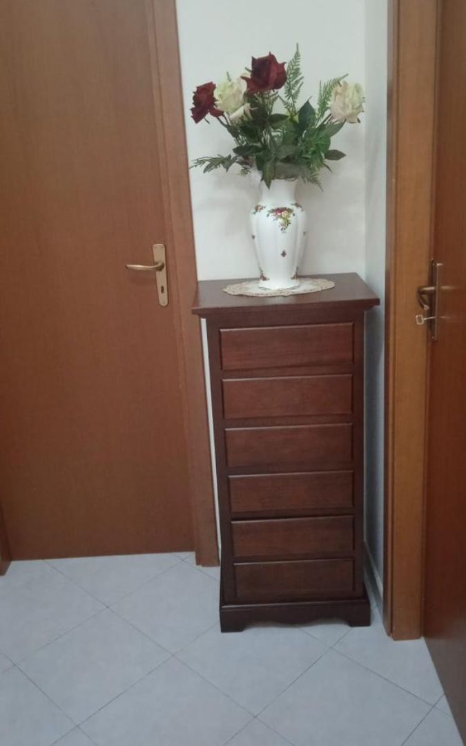 Cassettiera in legno noce scuro con sei cassetti, vista frontale prima dell'imballaggio.