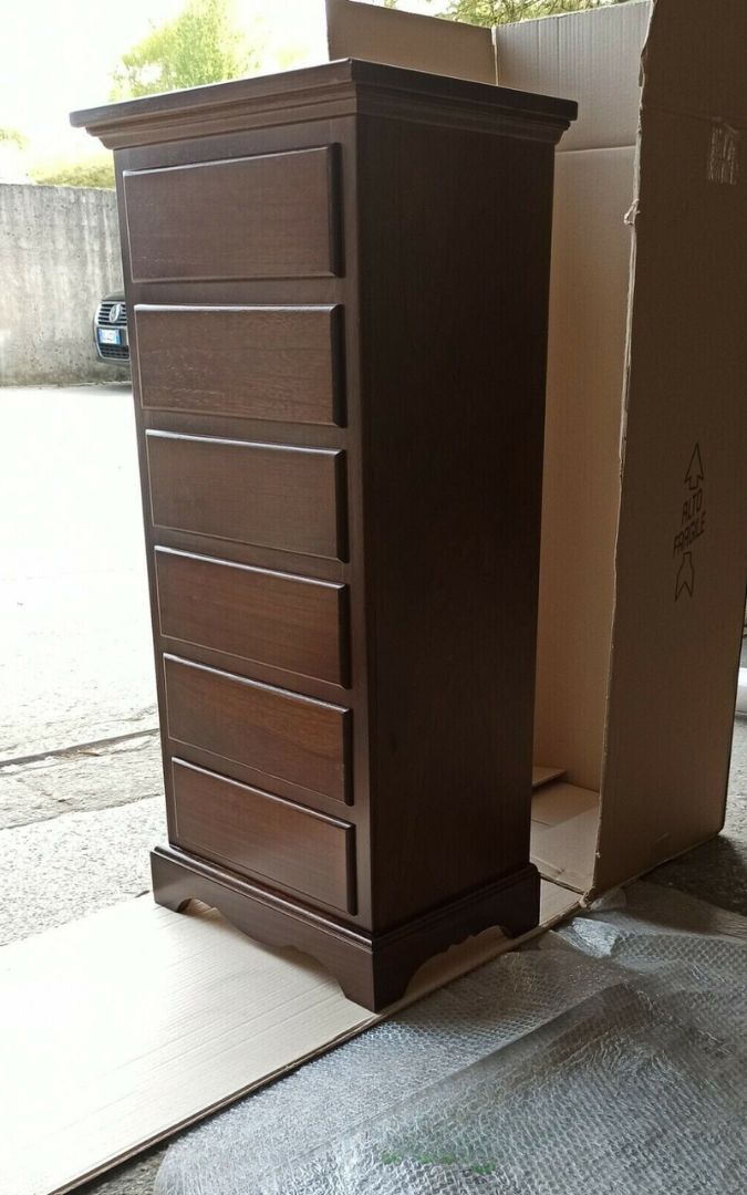 Cassettiera classica in legno noce scuro a sei cassetti, decorata con un vaso di fiori.