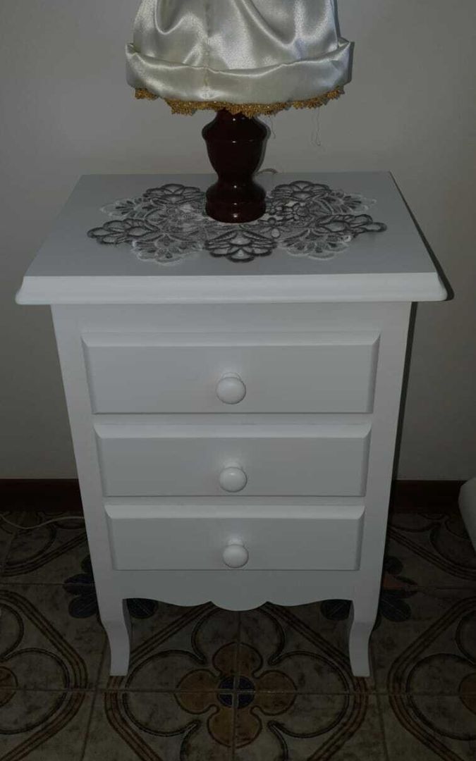 Comodino in legno bianco opaco, design elegante con tre cassetti, ideale per arredamento tradizionale.