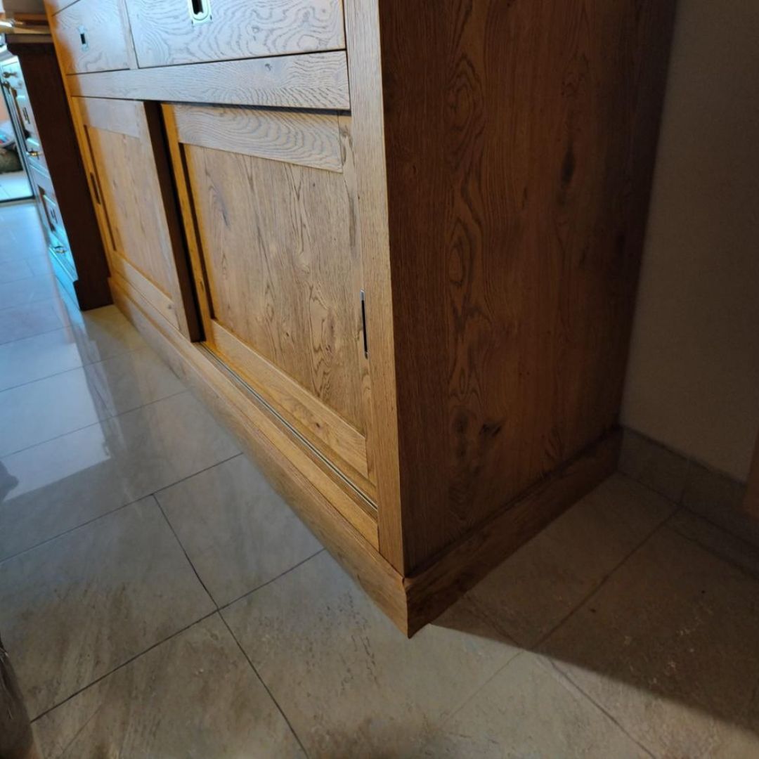 Credenza in rovere con anta scorrevole aperta e ripiano interno visibile