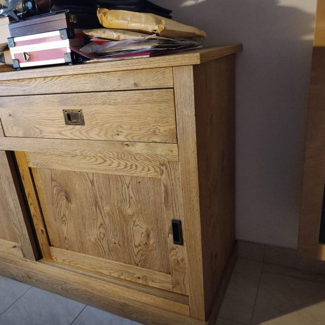 Dettaglio del fianco e del cassetto superiore della credenza in rovere, con maniglia a incasso.