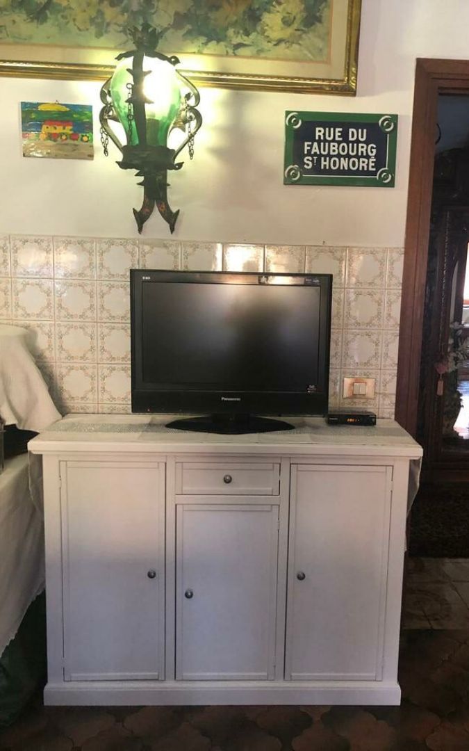 Credenza 3 ante in legno bianco opaco stile Arte Povera, vista frontale del mobile con cassetto centrale.
