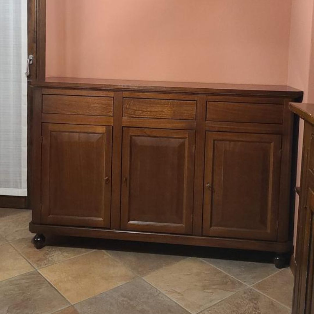 Credenza in legno color noce scuro con tre ante e tre cassetti, stile classico.