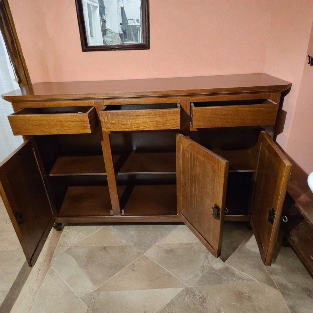 Credenza in legno scuro con tre cassetti aperti e ante aperte che mostrano i ripiani interni.
