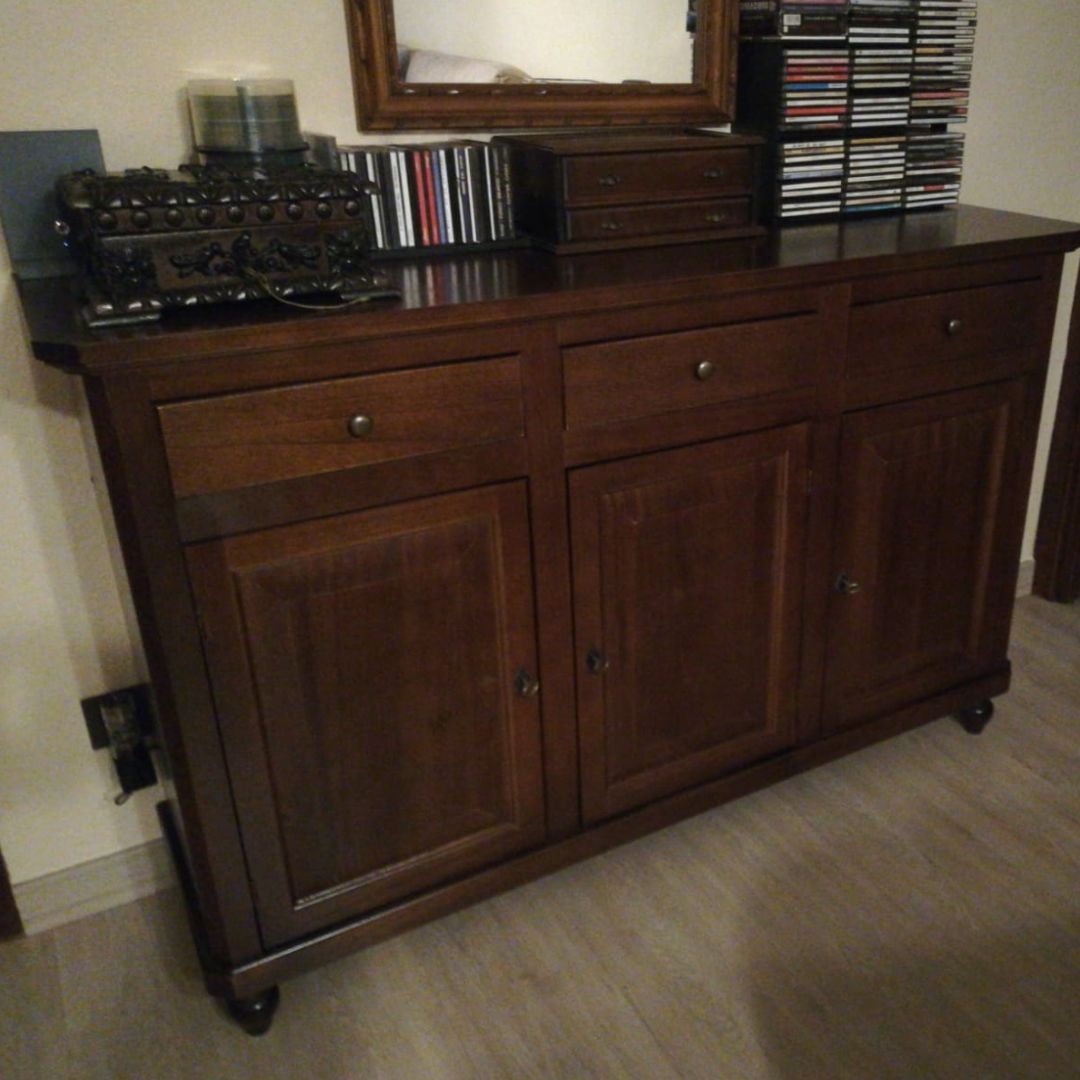 Credenza in noce scuro con oggetti ornamentali sopra, posizionata in un ambiente domestico.