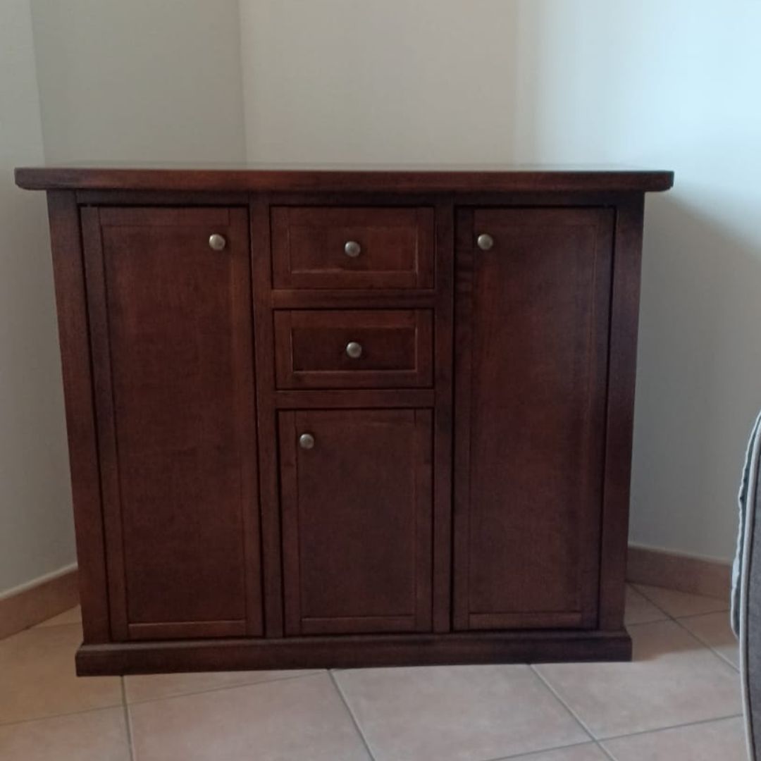 Vista frontale di credenza classica in legno di pioppo noce scuro, tre ante e due cassetti.