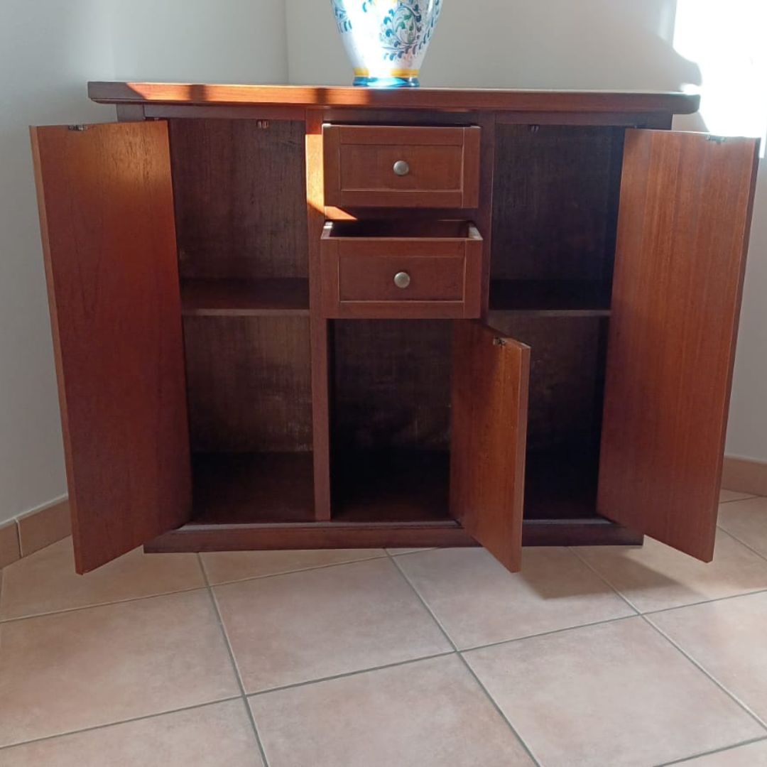 Credenza in legno noce scuro stile arte povera con ante aperte che mostrano il vano interno e i cassetti.