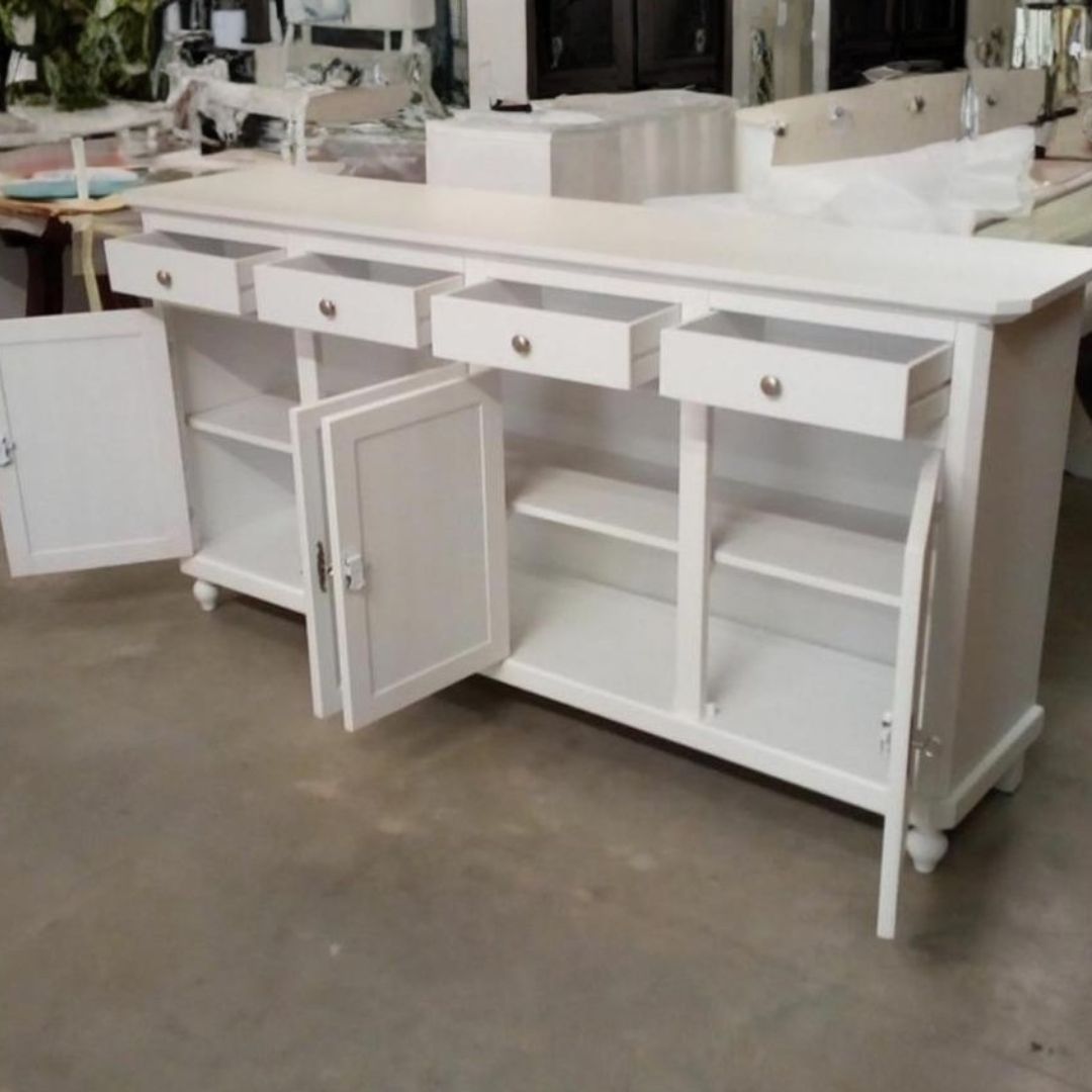 Dettaglio di una credenza in legno bianco con decorazioni floreali sulla superficie superiore.
