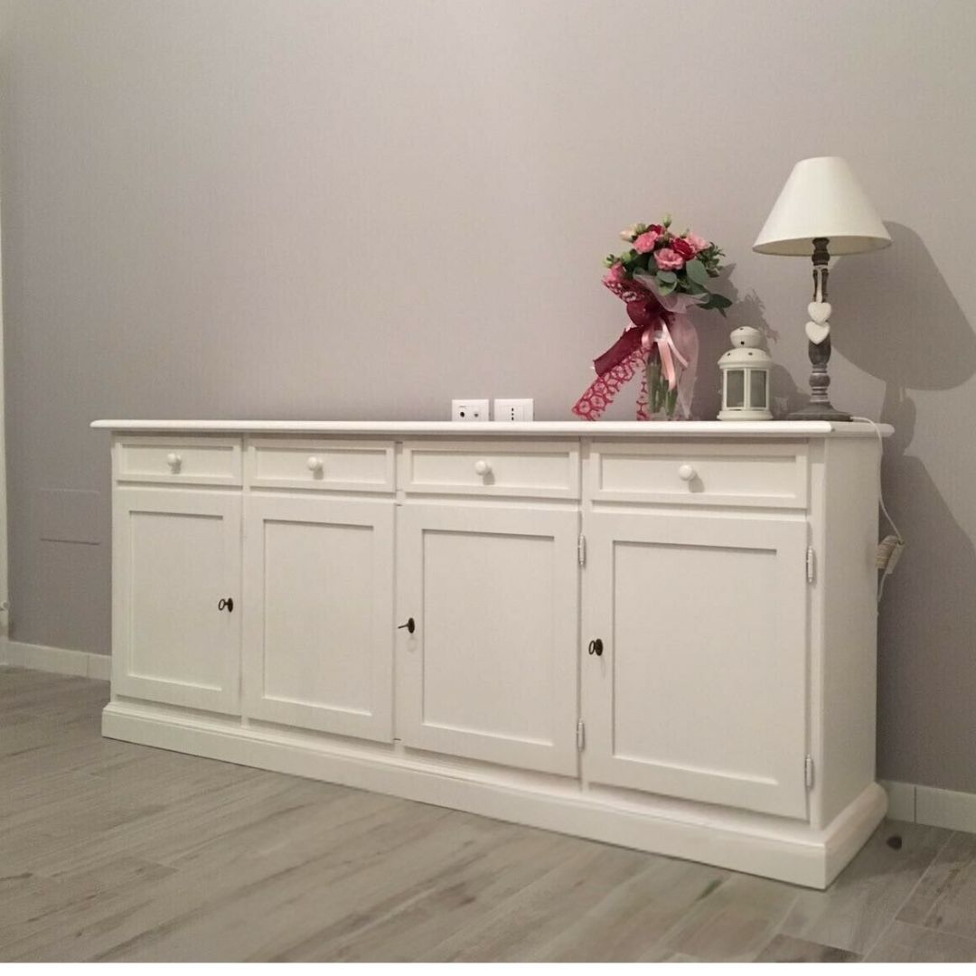 Credenza bianca 4 ante e 4 cassetti, vista d'insieme su pavimento in legno.