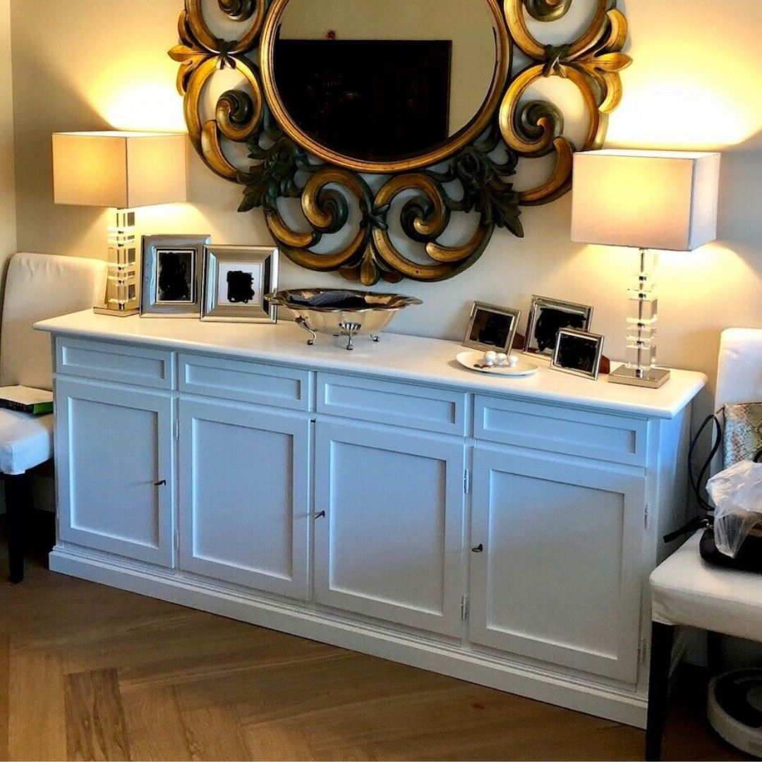Credenza 4 ante bianca con specchio rotondo barocco e lampade da tavolo.