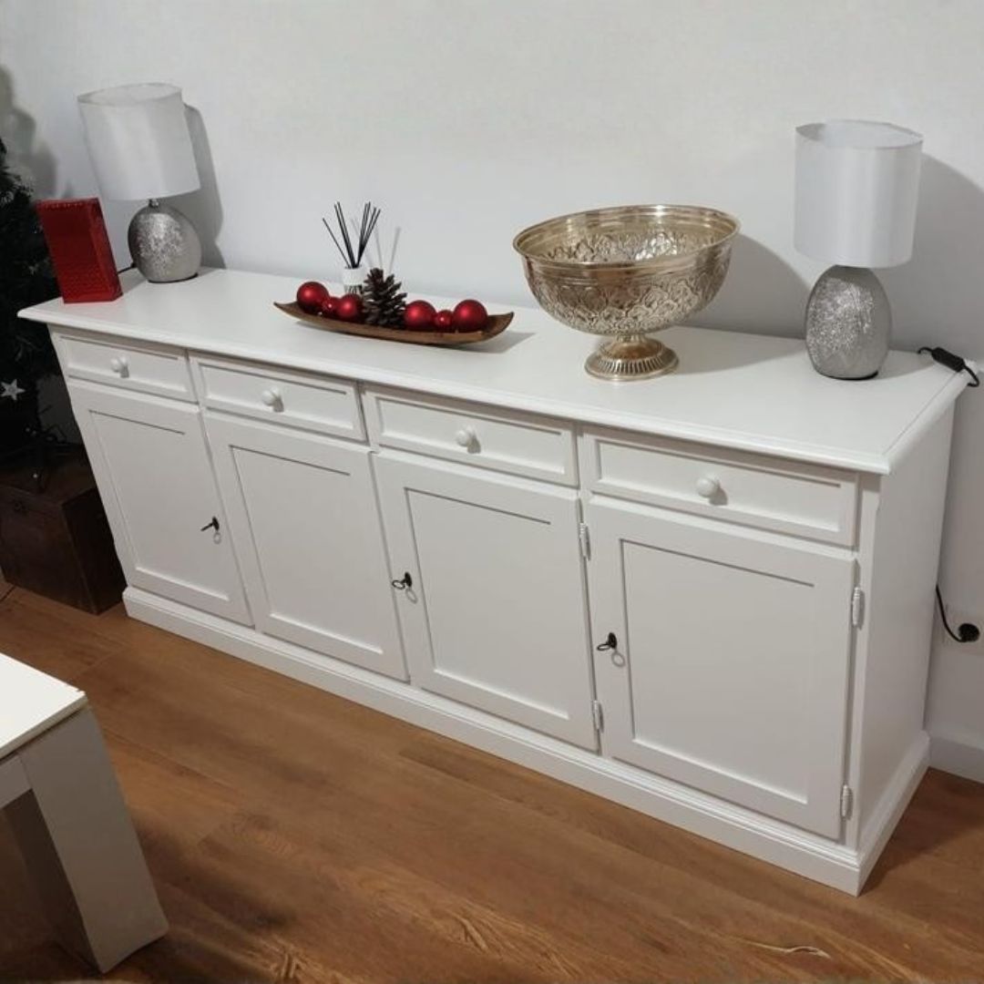 Credenza bianca 4 ante e 4 cassetti con oggetti decorativi sopra il piano.