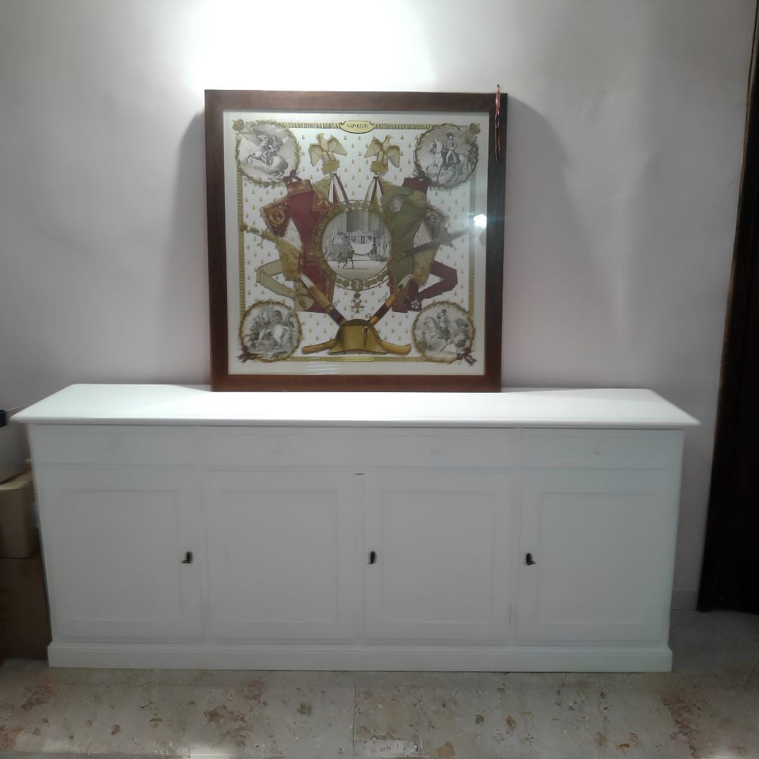 Credenza 4 ante stile arte povera su parete azzurra con orologio a muro.
