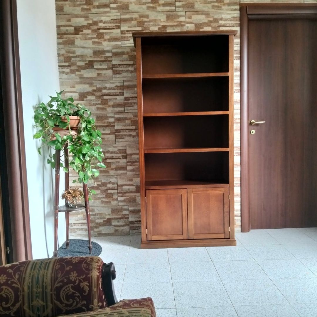 Libreria classica in legno noce scuro con base a due ante, posizionata in un ambiente arredato.