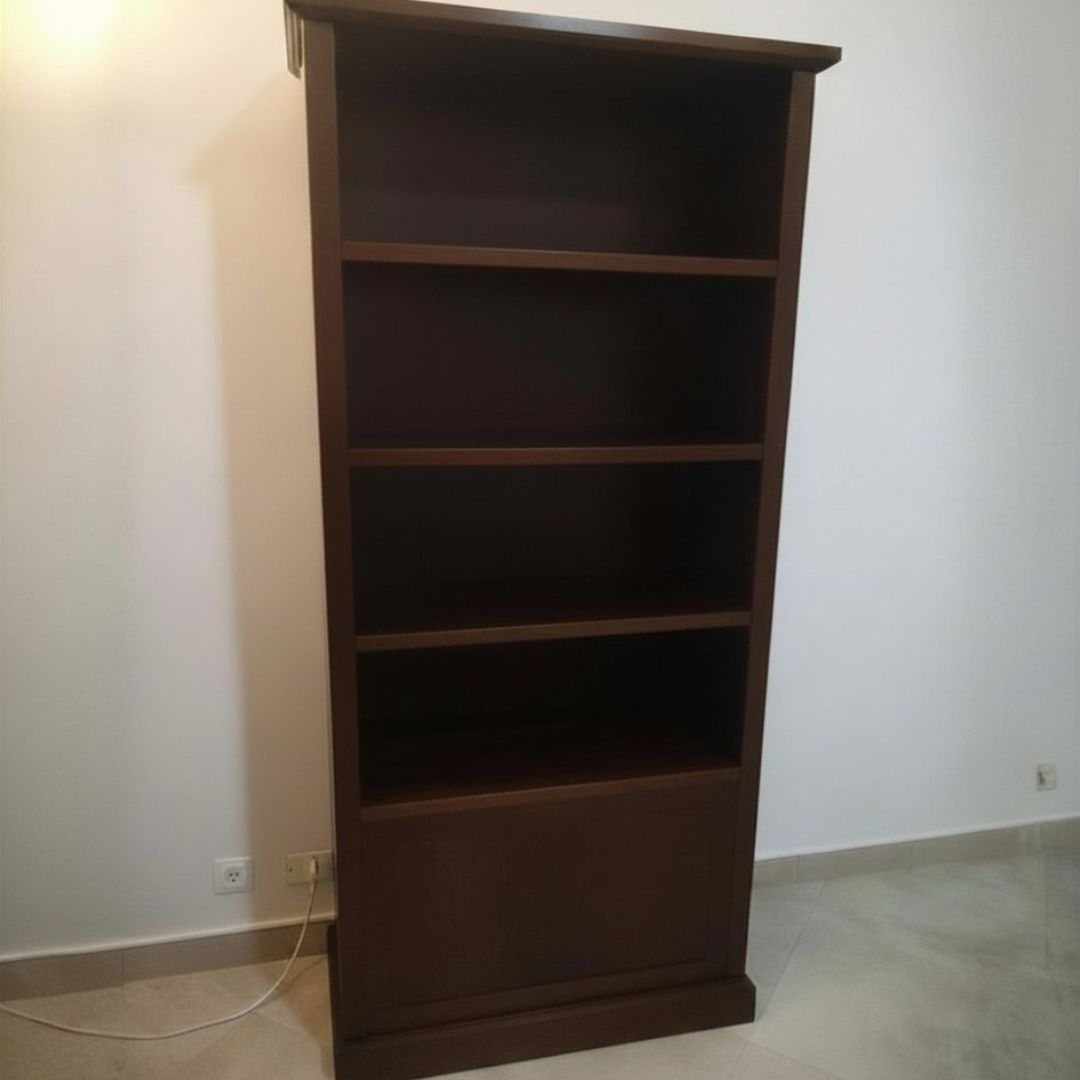 Libreria in legno massello noce scuro dal design classico con ripiani a vista e vano chiuso.