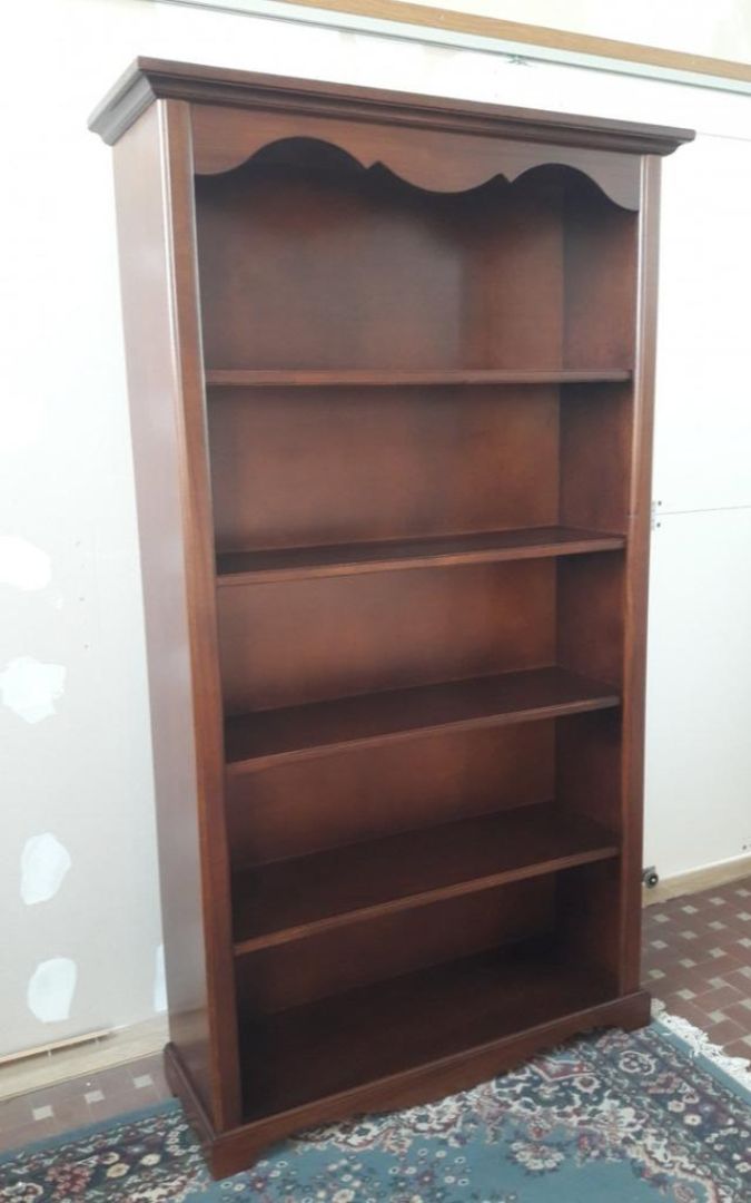 Vista frontale di una libreria in legno noce scuro a cinque ripiani, stile classico.
