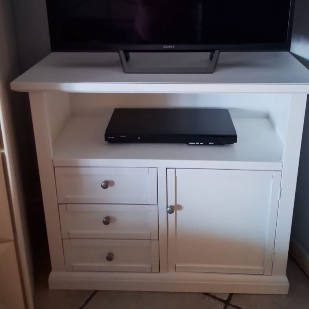 Mobile basso per televisione colore bianco opaco, dotato di tre cassetti e anta laterale.