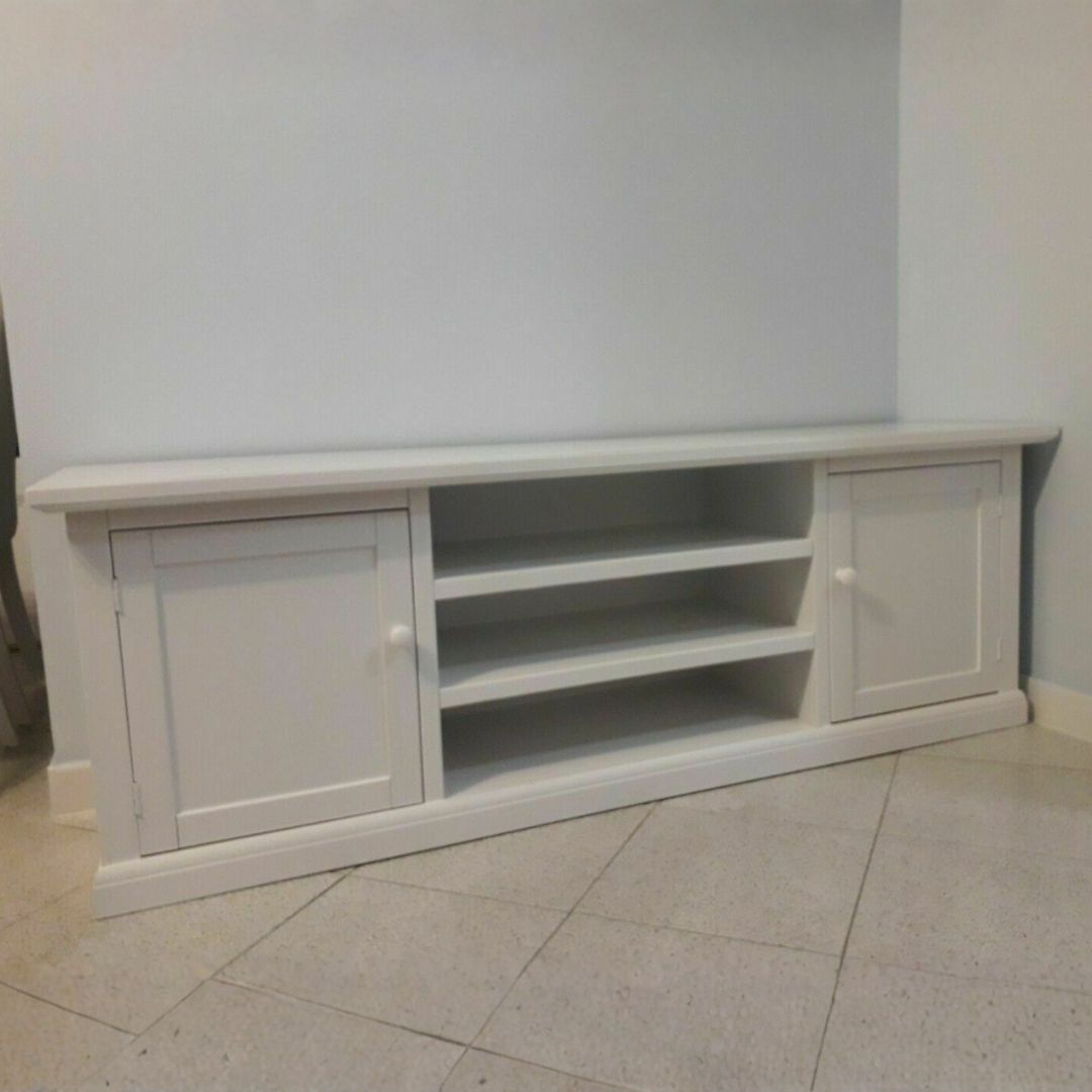 Dettaglio dell'interno di un mobile porta TV bianco con anta aperta, mostrando l'ampio spazio di archiviazione.