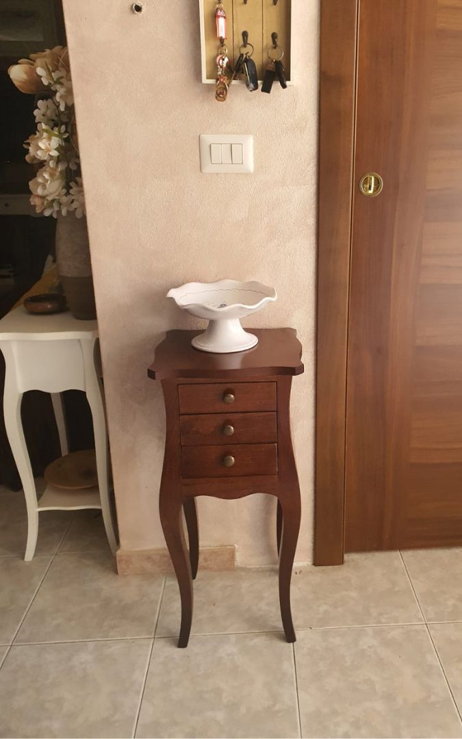 Mobile porta telefono Francesino in noce con tre cassetti, finitura classica, vista frontale con soprammobile.