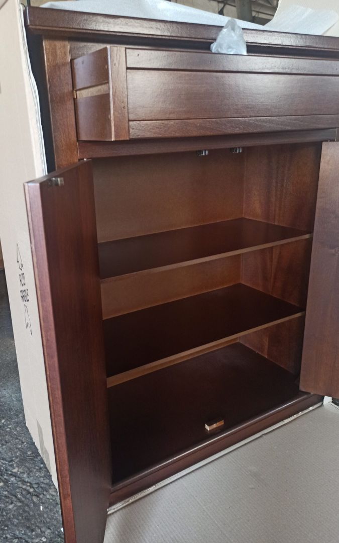 Elegante scarpiera in legno noce scuro con ripiani, collocata vicino a una finestra.