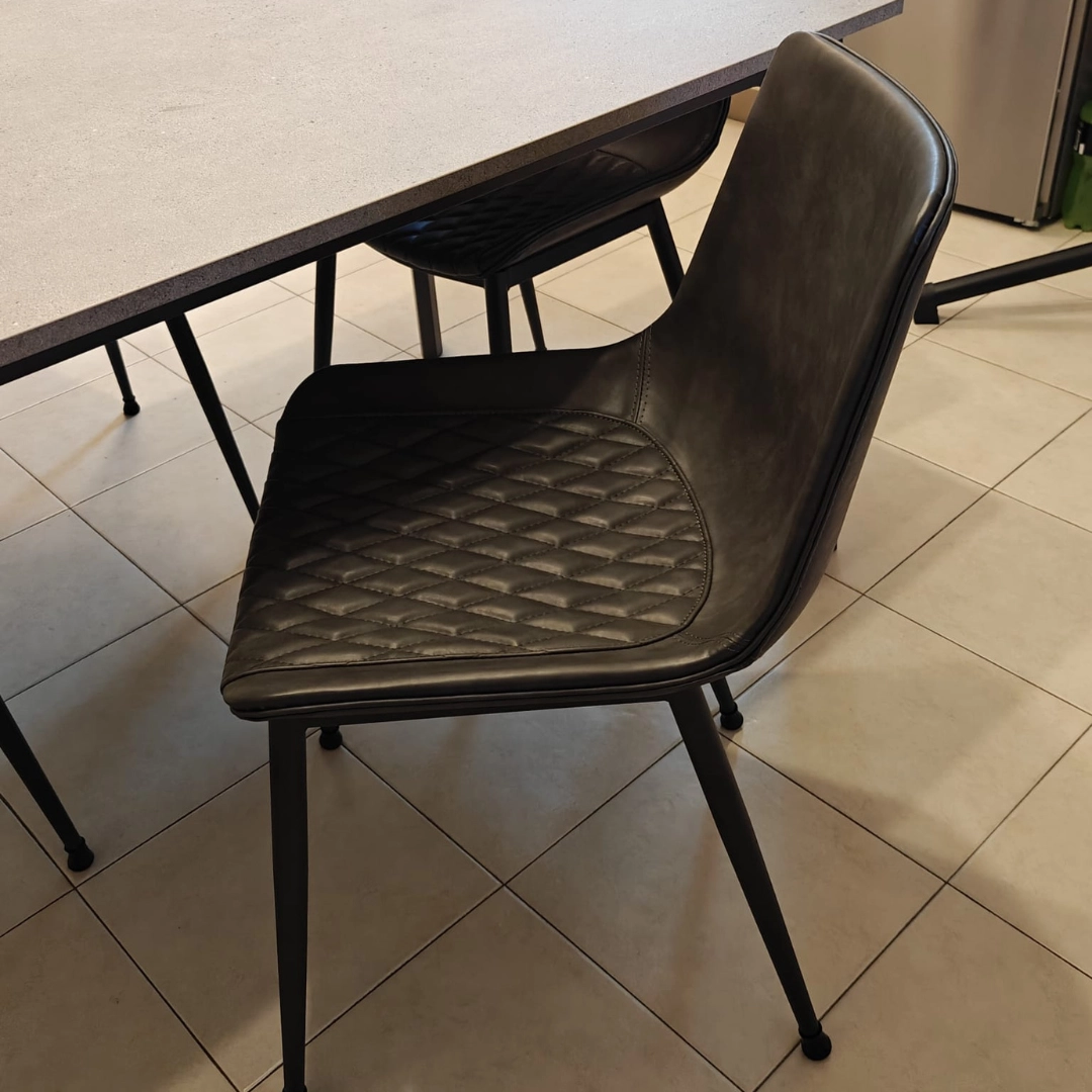 Set 2 sedie antracite imbottite in ecopelle posizionate attorno al tavolo da pranzo - Marca Design Shop