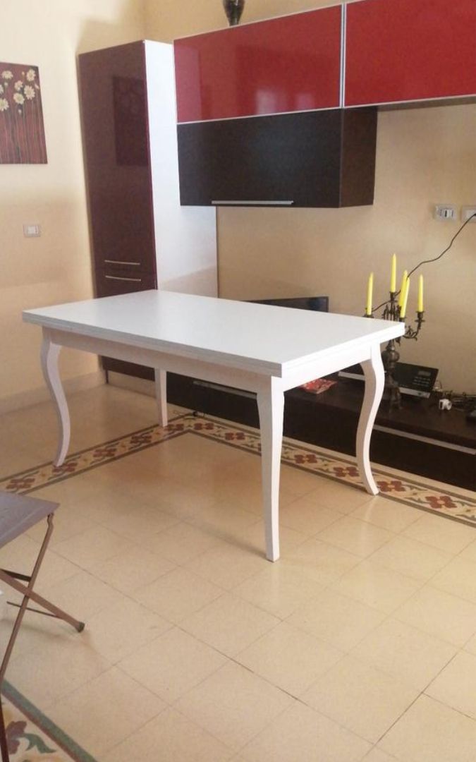 Tavolo allungabile rettangolare in legno bianco opaco con eleganti gambe a sciabola.