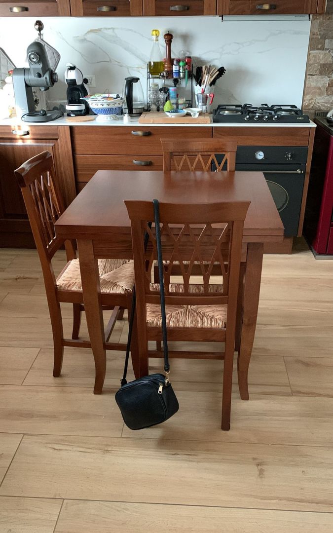 Tavolo da sala da pranzo in legno di pioppo, allungabile e rifinito in noce scuro.