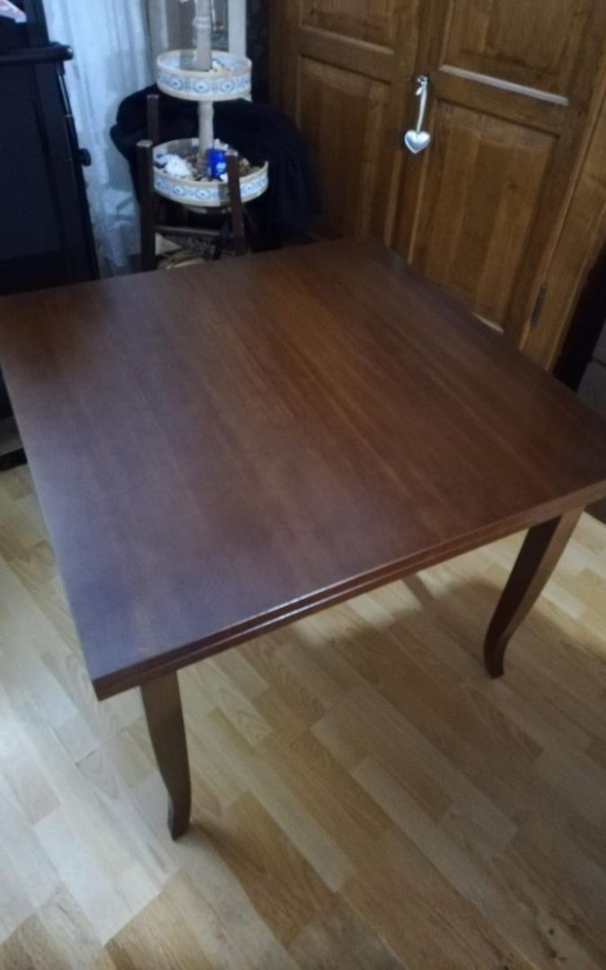 Dettaglio gambe a sciabola di tavolo allungabile in legno di pioppo tinta noce.