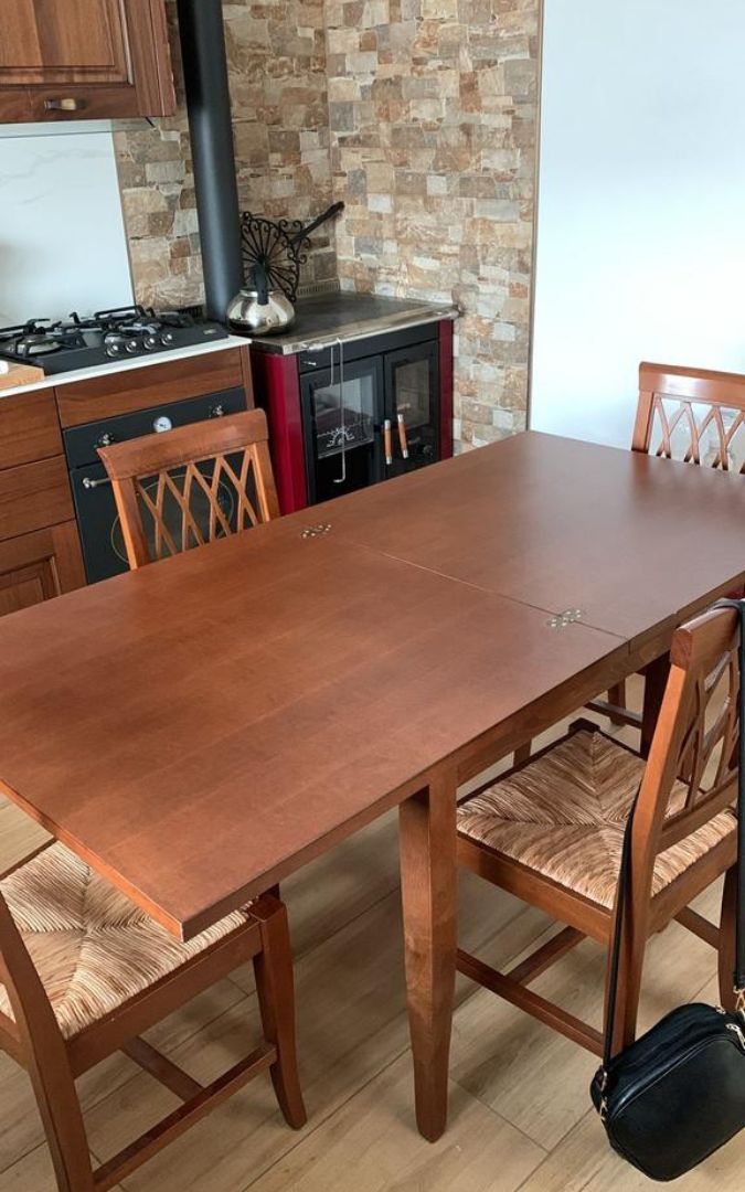 Tavolo rettangolare allungabile color noce scuro, perfetto per arredamento stile classico.