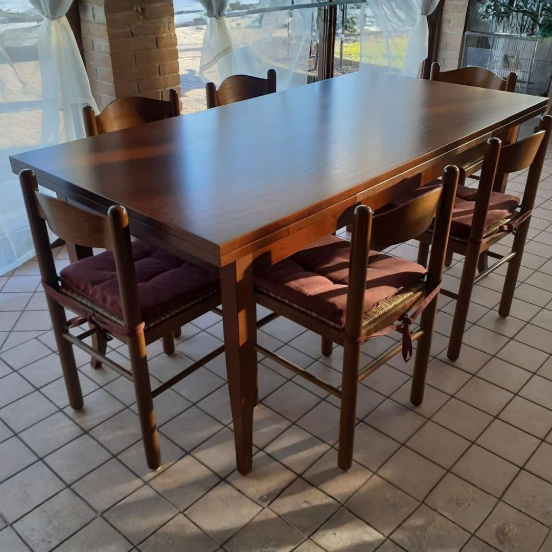 Tavolo da pranzo allungabile rettangolare in legno massello color noce.