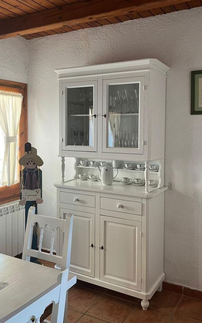 Vetrina da sala in legno bianco opaco con zona a giorno e chiusure a sportello.
