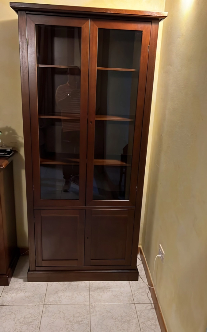 Vetrina in legno finitura noce vista di tre quarti in ambiente arredato