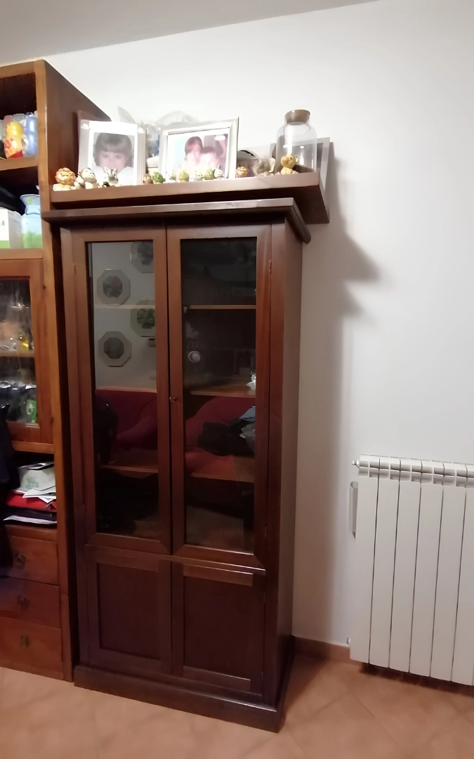 Vetrina in legno arte povera finitura noce collocata all'ingresso di una cucina