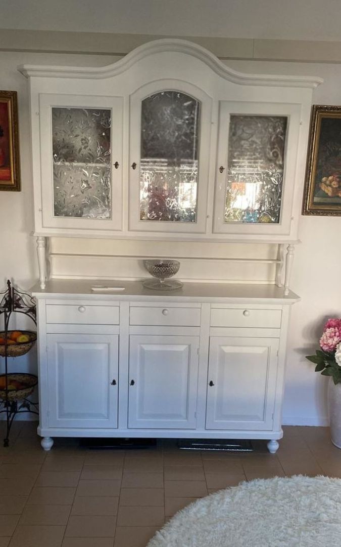 Vetrina completa in legno bianco stile Arte Povera, dotata di tre ante vetrate superiori e tre cassetti inferiori.