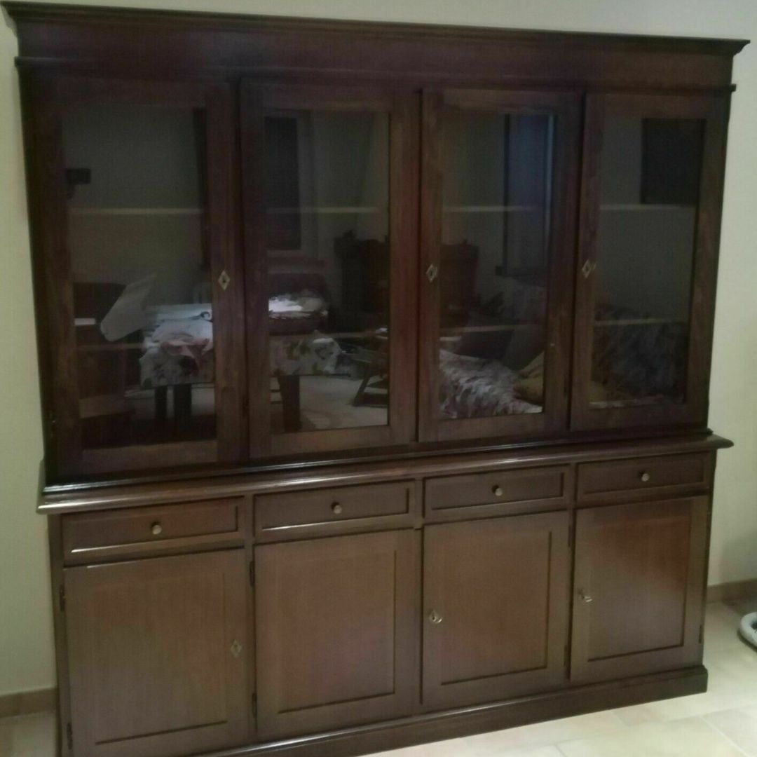 Vetrina da salotto in legno scuro con ante a vetro e vani chiusi in basso