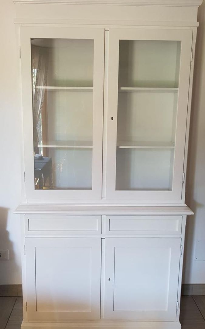 Vetrina in legno bianco opaco con due porte vetrate, due cassetti e ripiani interni, stile Arte Povera.