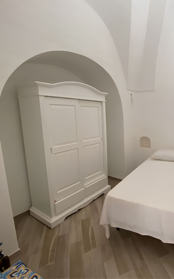 Vista frontale armadio stile gendarme con ante scorrevoli bianco opaco.