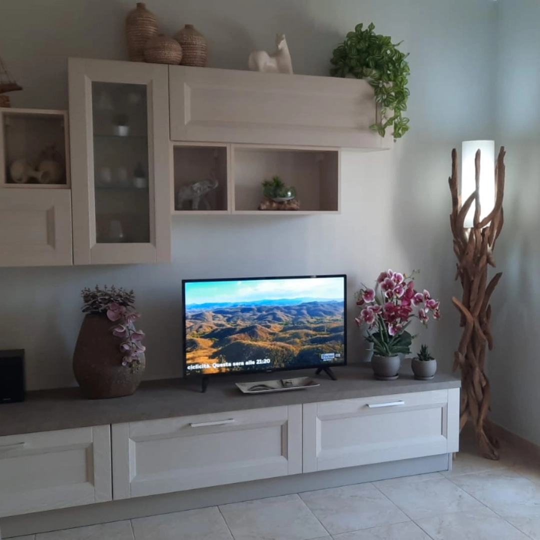 Parete attrezzata modulare moderna Marca Design in legno chiaro con pensili, ante in vetro e base TV tortora.