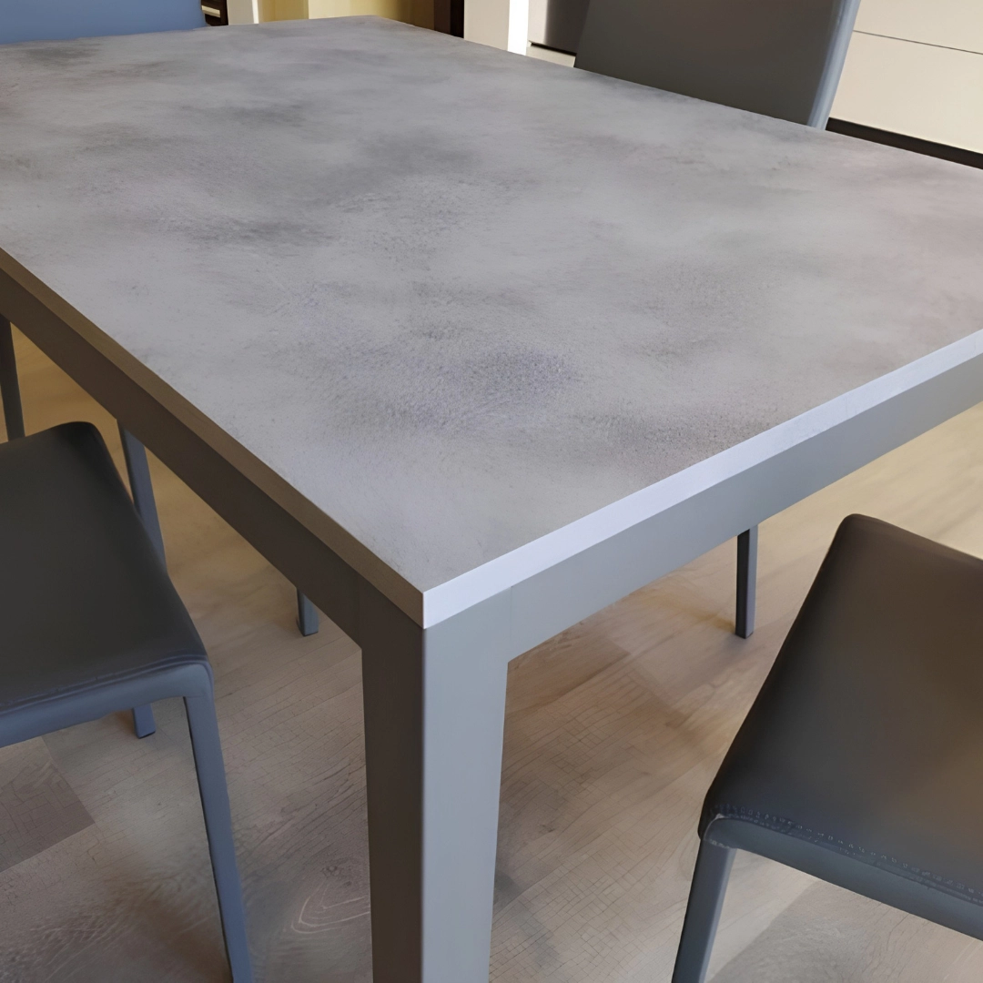 Angolo del tavolo allungabile moderno con piano grigio materico e struttura in metallo